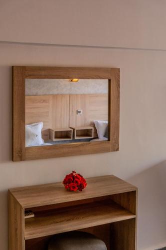 a mirror in a room with a table with a flower on it at Imperial Holiday Hôtel & spa in Marrakesh