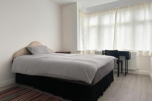 een slaapkamer met een bed, een tafel en een raam bij Rehoboth Housing in Cranford
