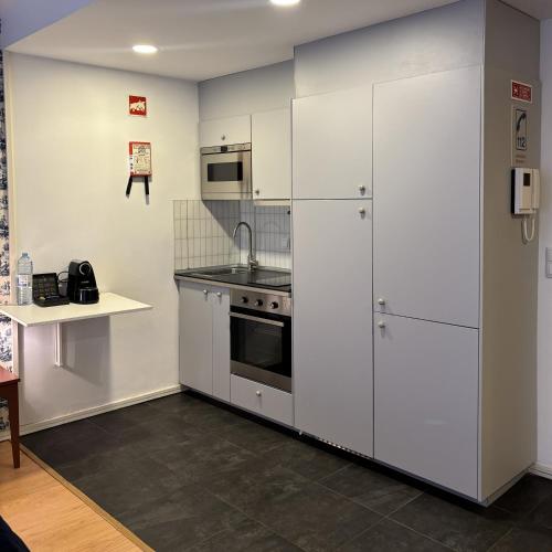 a kitchen with white cabinets and a stove at Be Oporto Apartments Clérigos in Porto