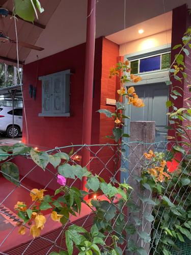 Srirangam Heritage Farmhouse - Perfect Spot for Parties & Events في تيروتشيرابالي: منزل امامه سياج وزهور