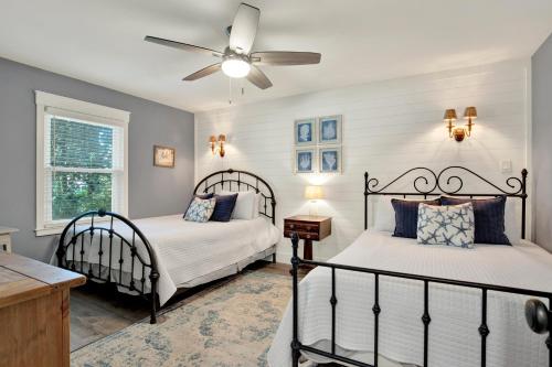 a bedroom with two beds and a ceiling fan at The Oar House in Tybee Island