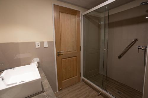 uma casa de banho com um lavatório e um chuveiro com uma porta de vidro em Hotel Rosario Uyuni Collection em Uyuni