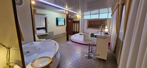 a bathroom with a tub and a sink and a bed at Love Suite vasca idromassaggio in Bologna
