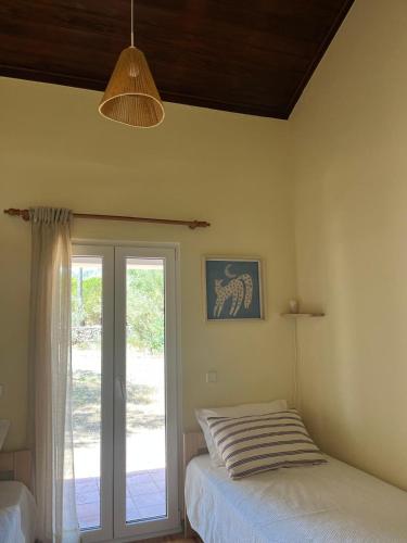 a bedroom with a bed and a sliding glass door at Casa Chã in Alcobertas