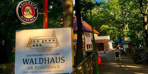 a sign hanging on a pole with a building at Waldhaus Weißwasser in Weißwasser