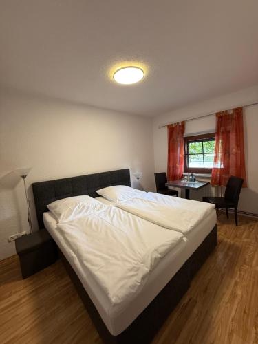 a bedroom with a bed and a table and a window at Waldhaus Weißwasser in Weißwasser