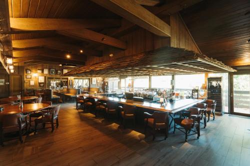 南派恩斯Pine Needles Lodge的铺有木地板、桌椅的餐厅