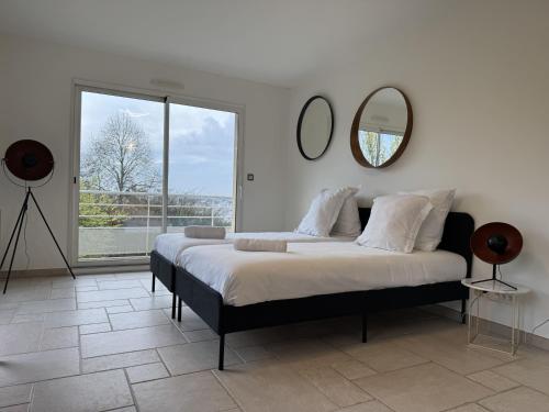 a bedroom with a large bed and a mirror at Villa Belvédère - Jacuzzi, Billard, Garage & Vue in Le Mans
