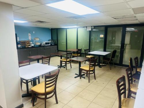 Un comedor con mesas y sillas y una cocina. en Days Inn by Wyndham Brooklyn Borough Park, en Brooklyn