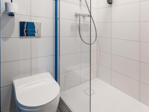 a bathroom with a shower and a toilet at ibis budget Mâcon Nord in Mâcon