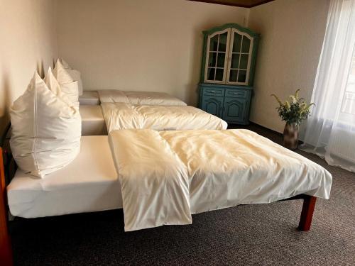 2 letti con lenzuola bianche in una stanza di Natascha a Fellen