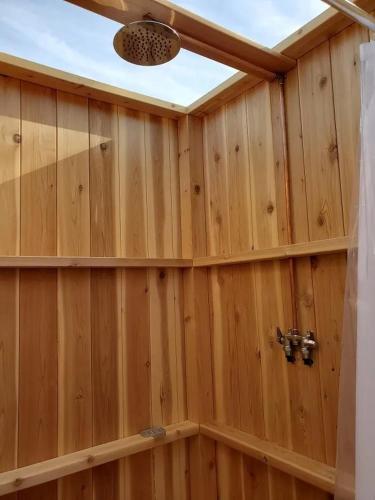 a bathroom with a wooden wall with a ceiling at North Fork Resort in Greenport