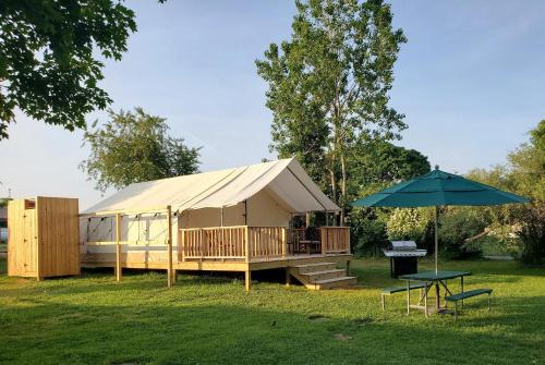 a large tent with a table and an umbrella at North Fork Resort in Greenport
