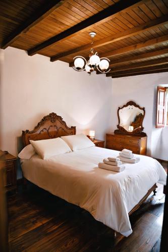 ein Schlafzimmer mit einem großen weißen Bett und einem Kronleuchter in der Unterkunft Casa do Botas in Sober