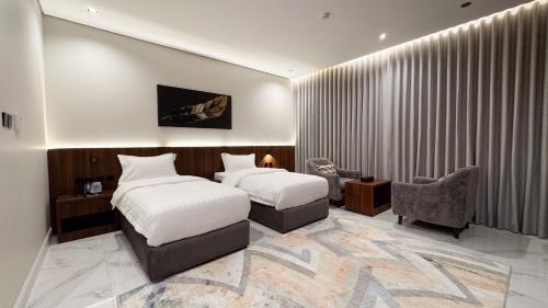 una stanza d'albergo con due letti e una sedia di فندق وفود فرع المدينة a Medina