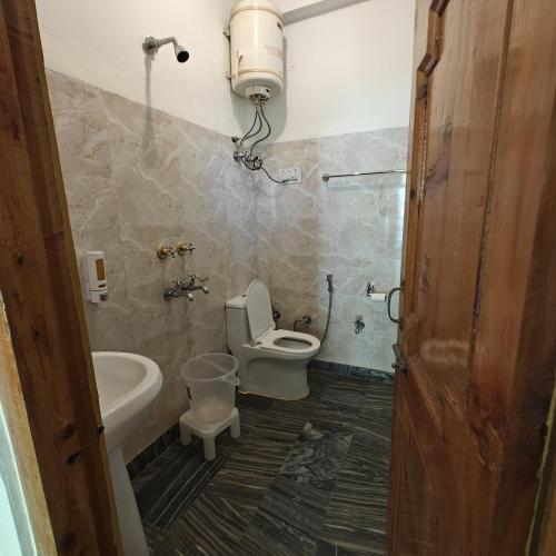 a bathroom with a toilet and a sink at Qpoint hotel in Kasol