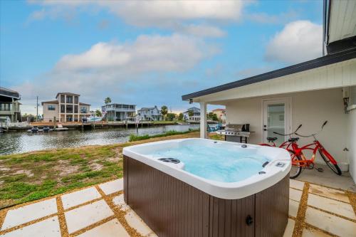 a hot tub on a patio next to a house at Oyster House Waterfront 3b2b Kayaks BBQ Games in Hernando Beach