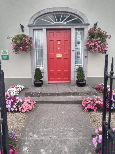 a red front door of a house with flowers at Townsend House Guest House in Birr