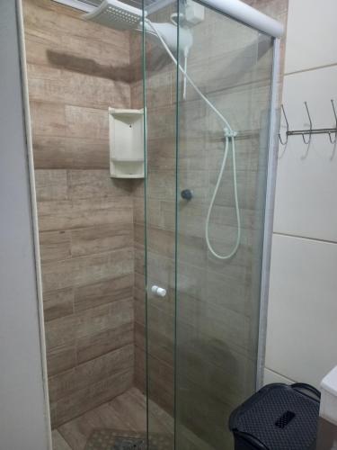 una doccia con una porta in vetro in un bagno di Kitnet mobiliado da Nice - FUNDOS a Guaíba