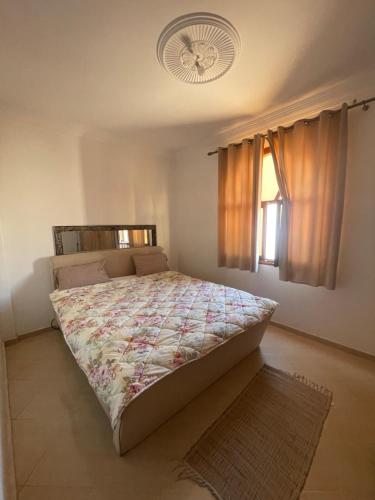 a bedroom with a large bed with a fan at Sunny Surf Riad apartment in Tamraght in Agadir