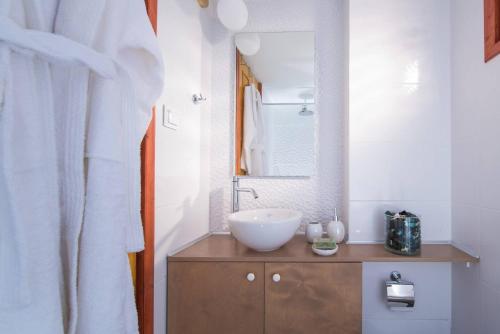 a bathroom with a white sink and a mirror at Nissos Home by Prime Stay in Hersonissos