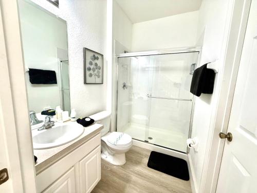 a white bathroom with a shower and a toilet at Windsor Hill Resort Minute to Disney & Theme Parks in Orlando