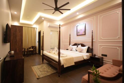 a bedroom with a bed with a ceiling fan at Rambagh Resort by Stotrak, Gwalior in Gwalior