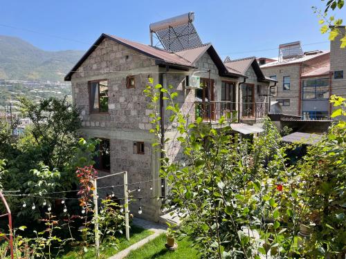 a stone house on a hill with a garden at Guest House Anahit Ijevan in Ijevan
