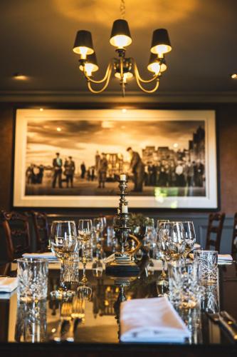 a table in a restaurant with glasses on it at Maryculter House in Maryculter