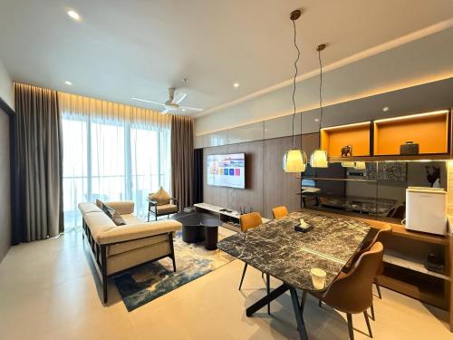 Genting Antara Residence, Covered Link Bridge access to Genting Highlands في مرتفعات جنتنغ: غرفة معيشة مع طاولة طعام وأريكة