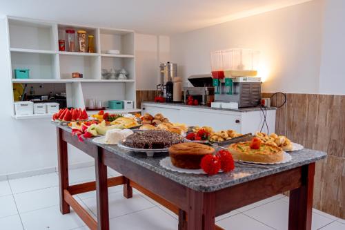 ein Tisch mit vielen verschiedenen Arten von Essen darauf in der Unterkunft Hotel do Pescador in Morro de São Paulo