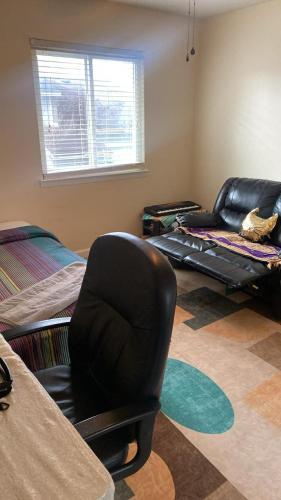 a living room with a black chair and a bed at Cozy, private room near Virginia Beach town center in Virginia Beach