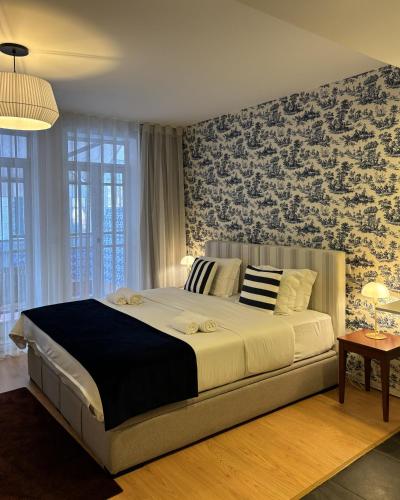 a bedroom with a large bed with a floral wall at Be Oporto Apartments Clérigos in Porto