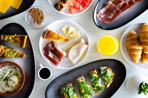 a table topped with plates of food and pastries at AC Hotel by Marriott New Orleans French Quarter in New Orleans