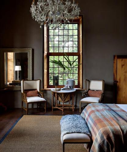 a bedroom with a chandelier and a table and chairs at Ballotina, Tulbagh Cape Wineland in Tulbagh