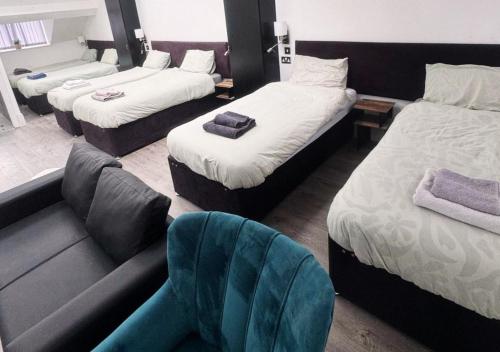een hotelkamer met 3 bedden en een bank bij Williamson Suites - Apartment 2 in Liverpool