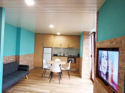 een woonkamer met een bank, een tafel en een tv bij Studio Casa Miradouro Fafião in Fafião