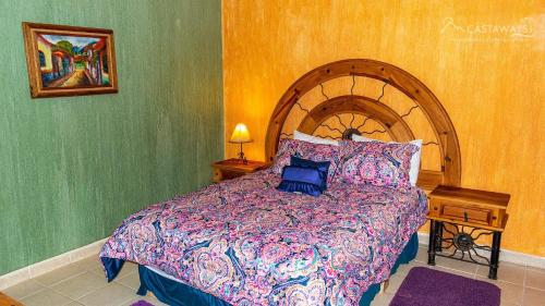 una camera da letto con un letto grande con testiera in legno di Sonoran Spa W403 a Campo del Medio