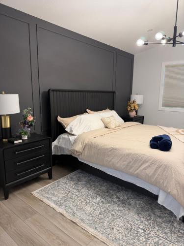 una camera da letto con un letto grande con testiera nera di Cozy Heaven a Saskatoon