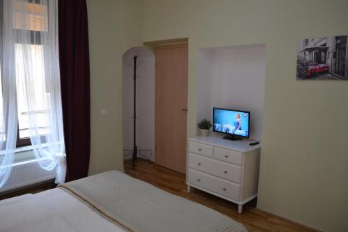 a bedroom with a bed and a television on a dresser at Casa Krone - Piața Sfatului in Braşov