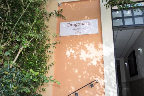 a sign on the side of a building with plants at Dragonara Apartments in St. Julianʼs