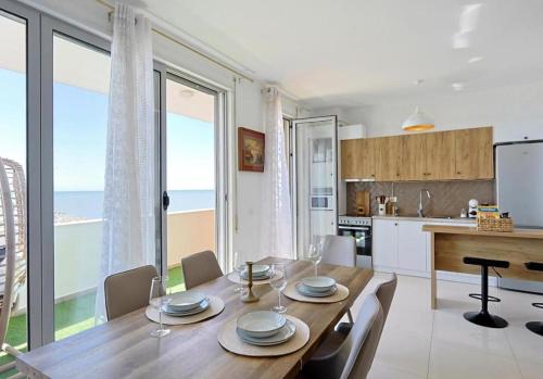 a kitchen and dining room with a wooden table and chairs at Shëngjin Shores Apartments in Shëngjin