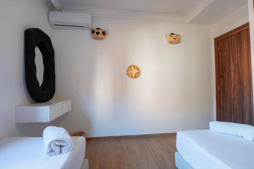 ein weißes Zimmer mit einem Sofa und einem Spiegel in der Unterkunft Luxury Central Apartment Marrakech Pool Near train station in Marrakesch