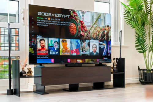 a large flat screen tv on a stand in a living room at Dote Haven Stylish 2 Bed Apartment - Free Parking and Free High Speed WIFI in Birmingham