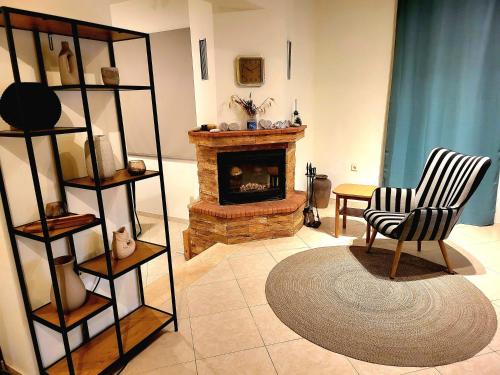 een woonkamer met een open haard en een stoel bij Aegean Helios Houses in Gennadi