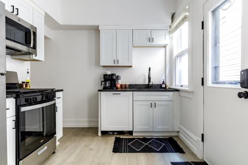 una cucina bianca con mobili bianchi e una finestra di Short North Convention King Bed Free Parking! a Columbus