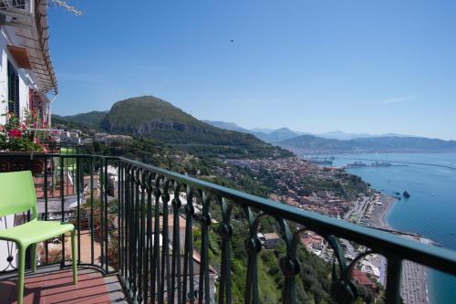 a balcony with a green chair overlooking the water at Casa Beatrice Amalfi Coast in Vietri sul Mare