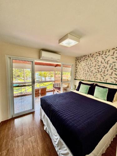 a bedroom with a bed with a blue comforter at Refúgio em Angra com Praia Privativa in Angra dos Reis