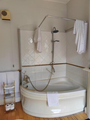 a bathroom with a tub and a shower with towels at Townsend House Guest House in Birr