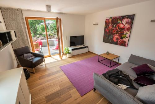 a living room with a couch and a tv at Ferienhaus am Park in Grafenau